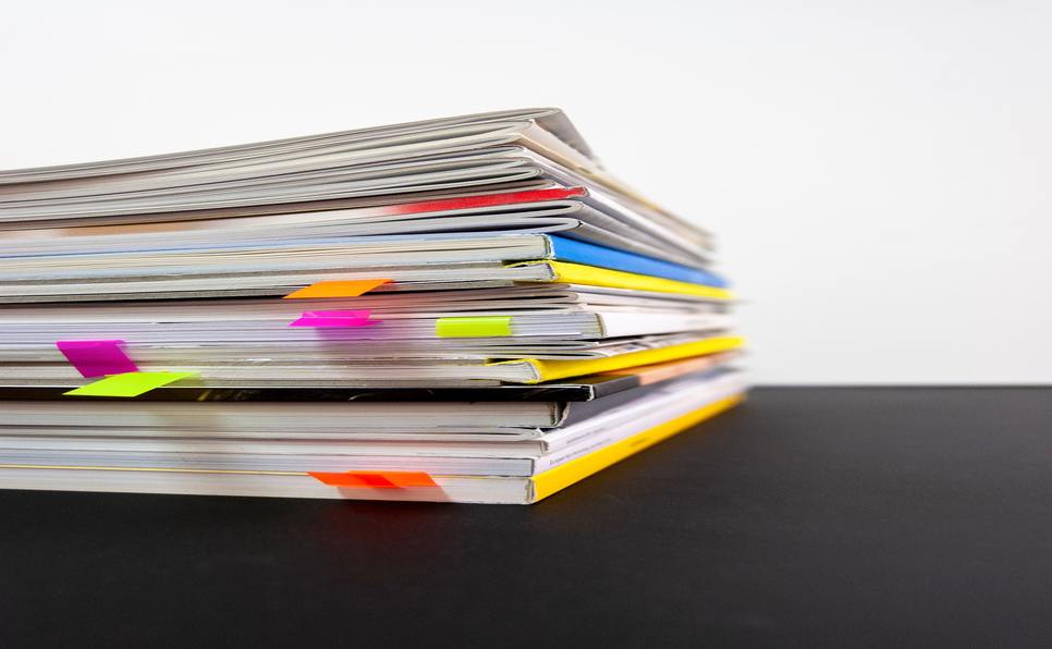 A stack of magazines with colorful bookmarks