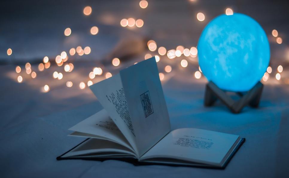 Open book with crystal ball and lights