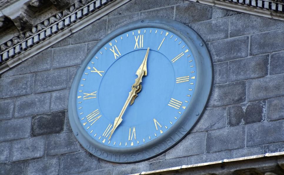 Blue clock on college building showing how long does it take to get an MFA in Creative Writing
